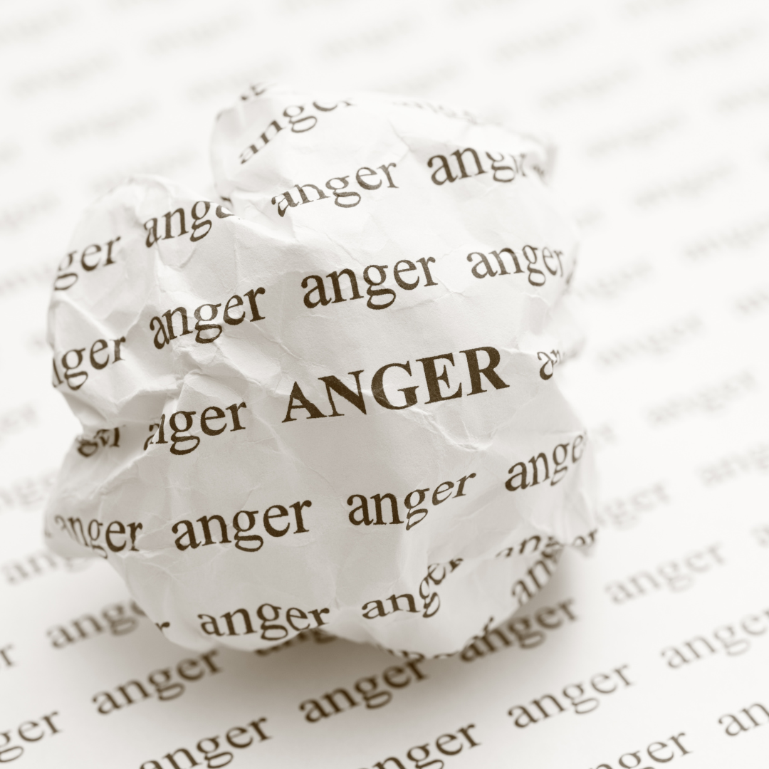 crumpled paper printed with the word “anger” representing difficult emotions