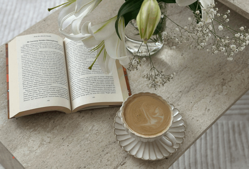 open book with coffee and flowers arranged for a quiet reading ritual