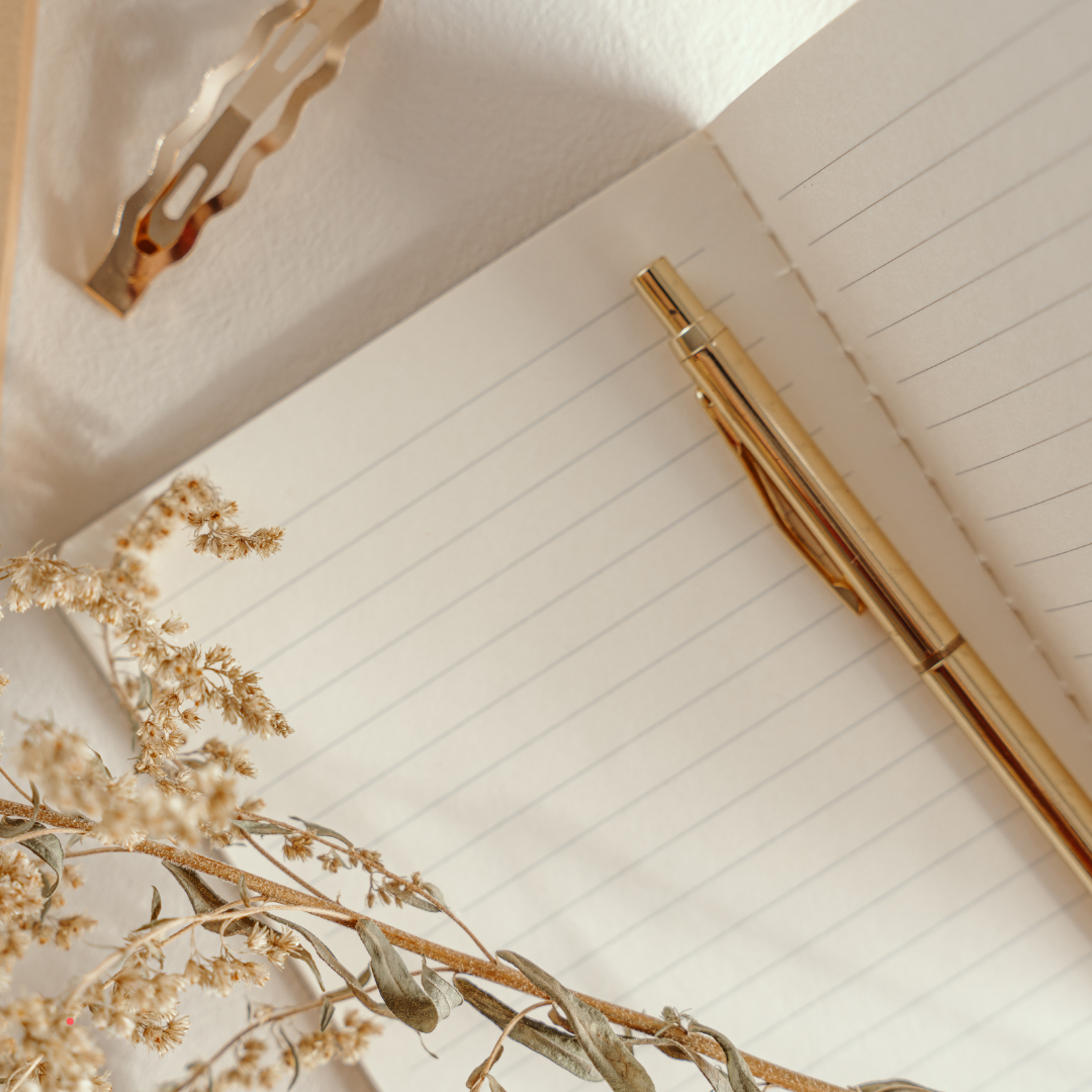 open lined notebook with pen and dried flowers prepared for writing