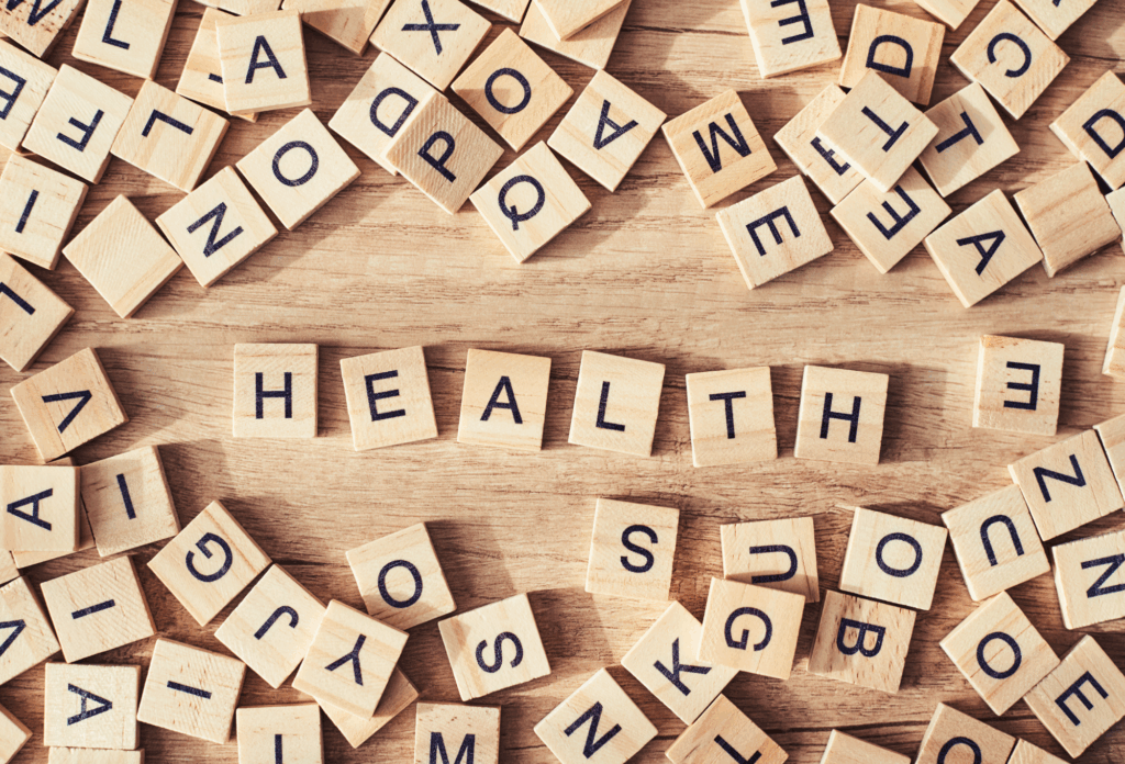 wooden letter tiles spelling “health” representing mental well-being