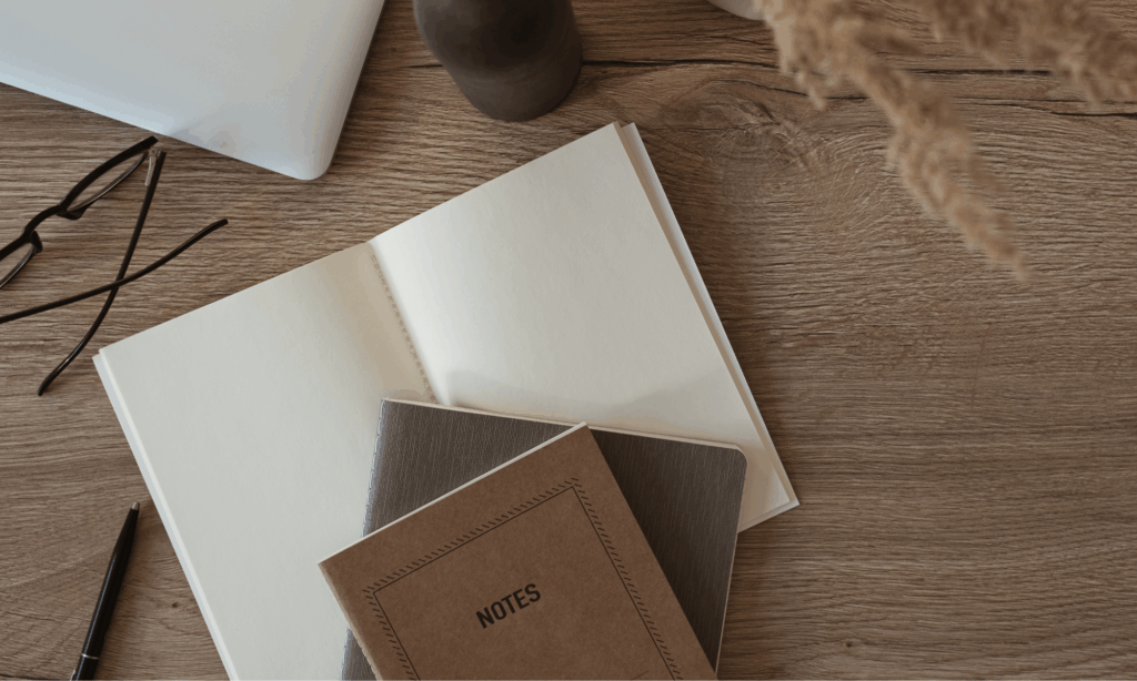 open notebooks and pen on a wooden desk prepared for reflective writing