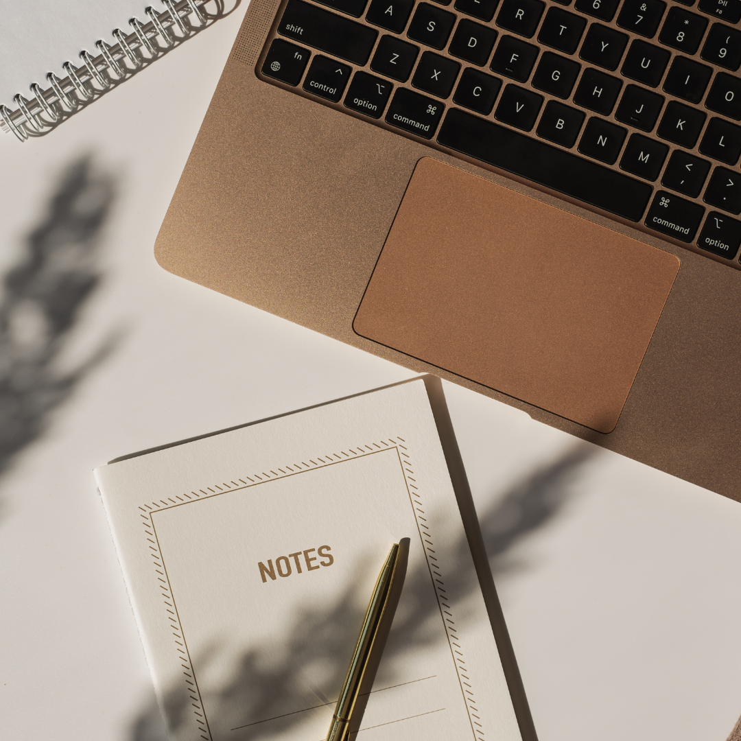 laptop and notebook on a desk during a focused writing moment