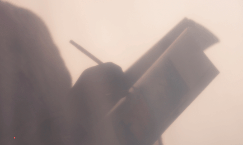 soft silhouette of a person writing in a notebook in warm light