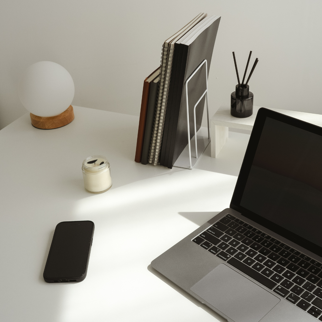 minimal writing workspace with laptop and notebooks in soft light