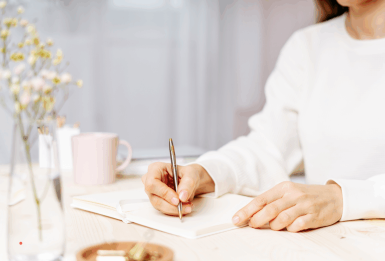 writing by hand in a notebook as part of an emotional journaling practice