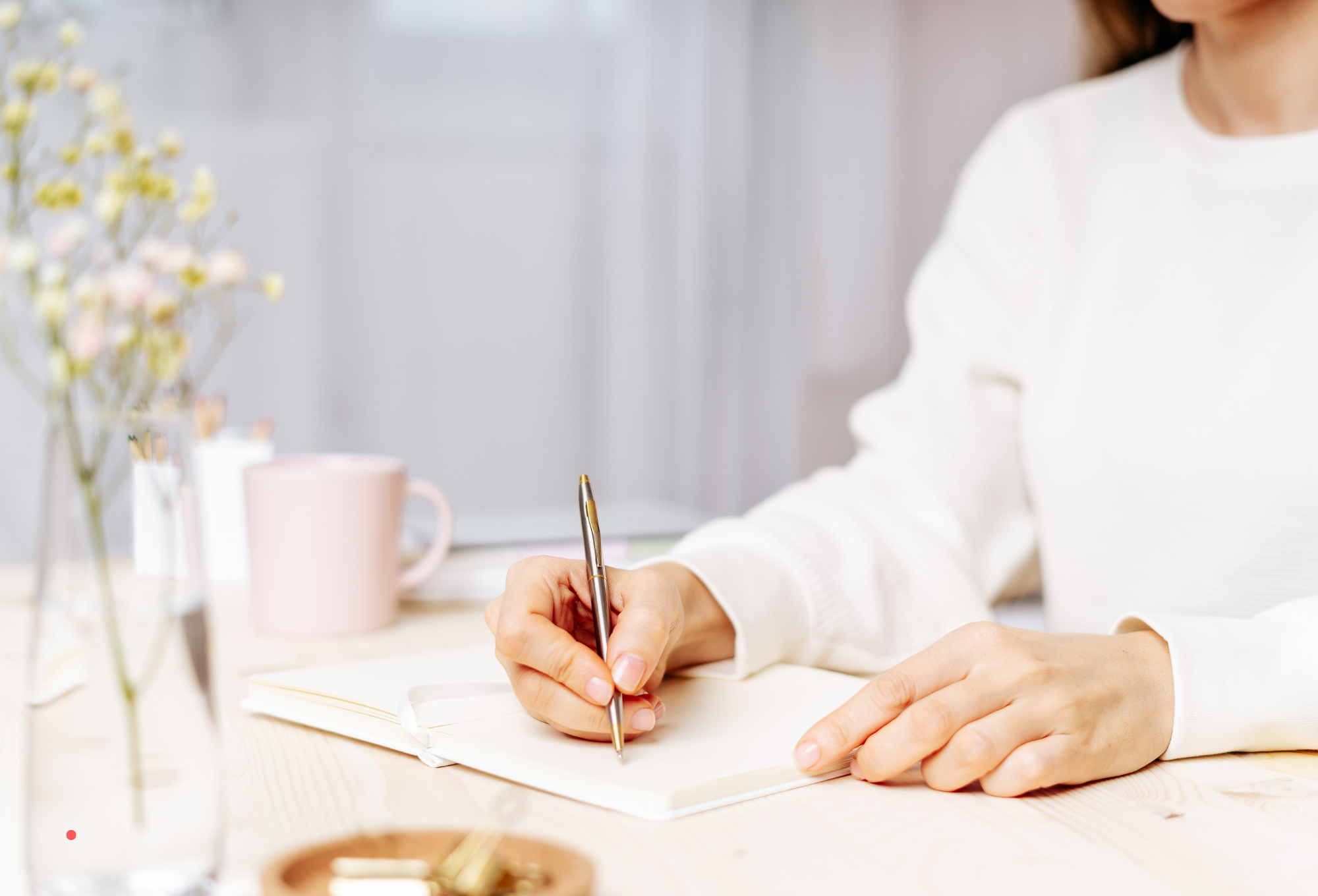 writing by hand in a notebook as part of an emotional journaling practice