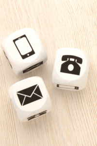 Minimal wooden cubes with phone and message icons, symbolizing simple and open ways to get in touch.