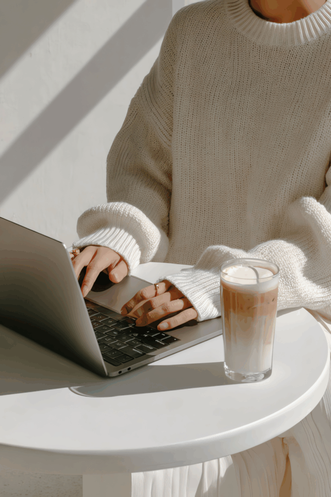 Person typing on a laptop beside a cup of coffee, representing a calm and welcoming space for written connection.