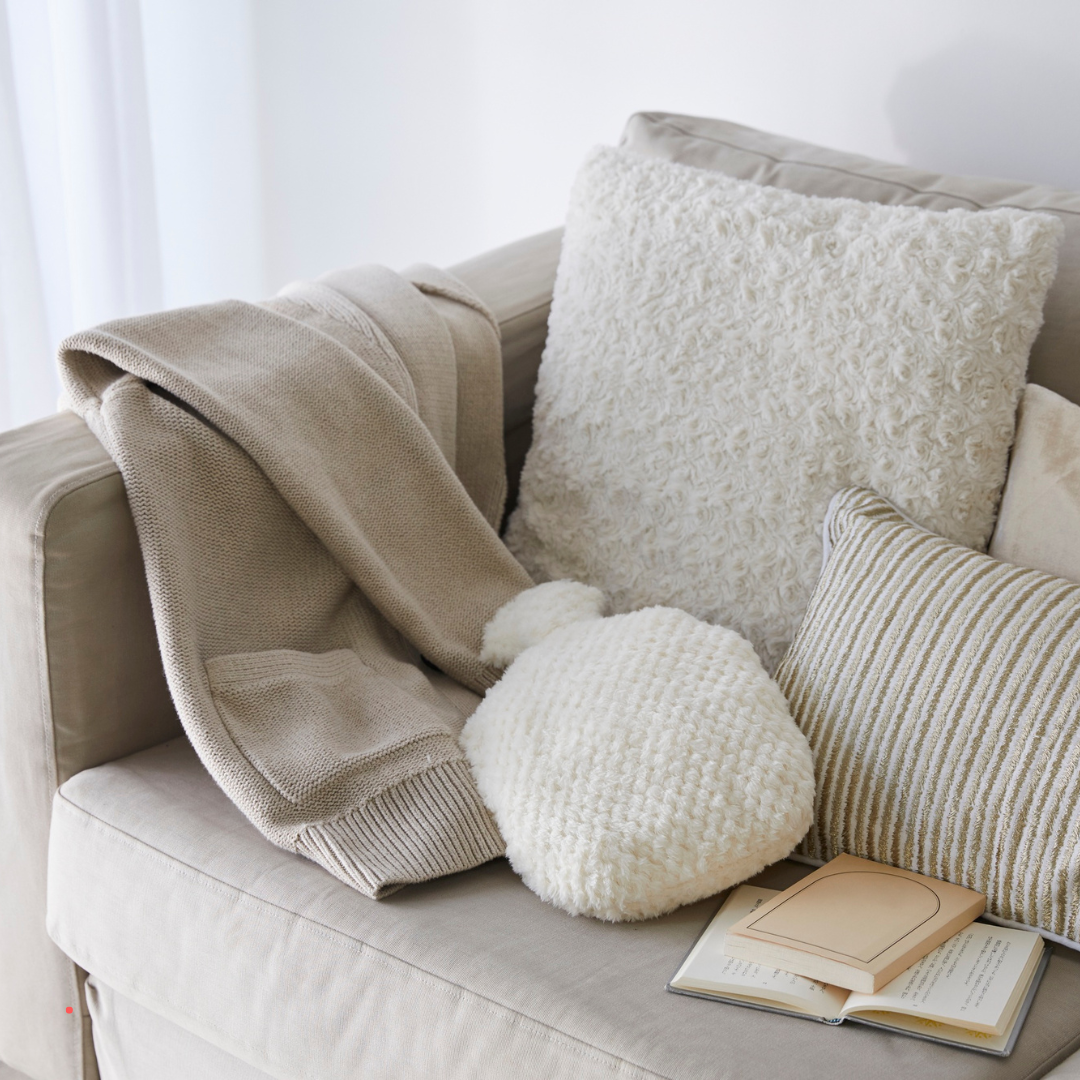 Cozy living space with soft pillows and a book, creating a safe and comforting environment for reflective writing
