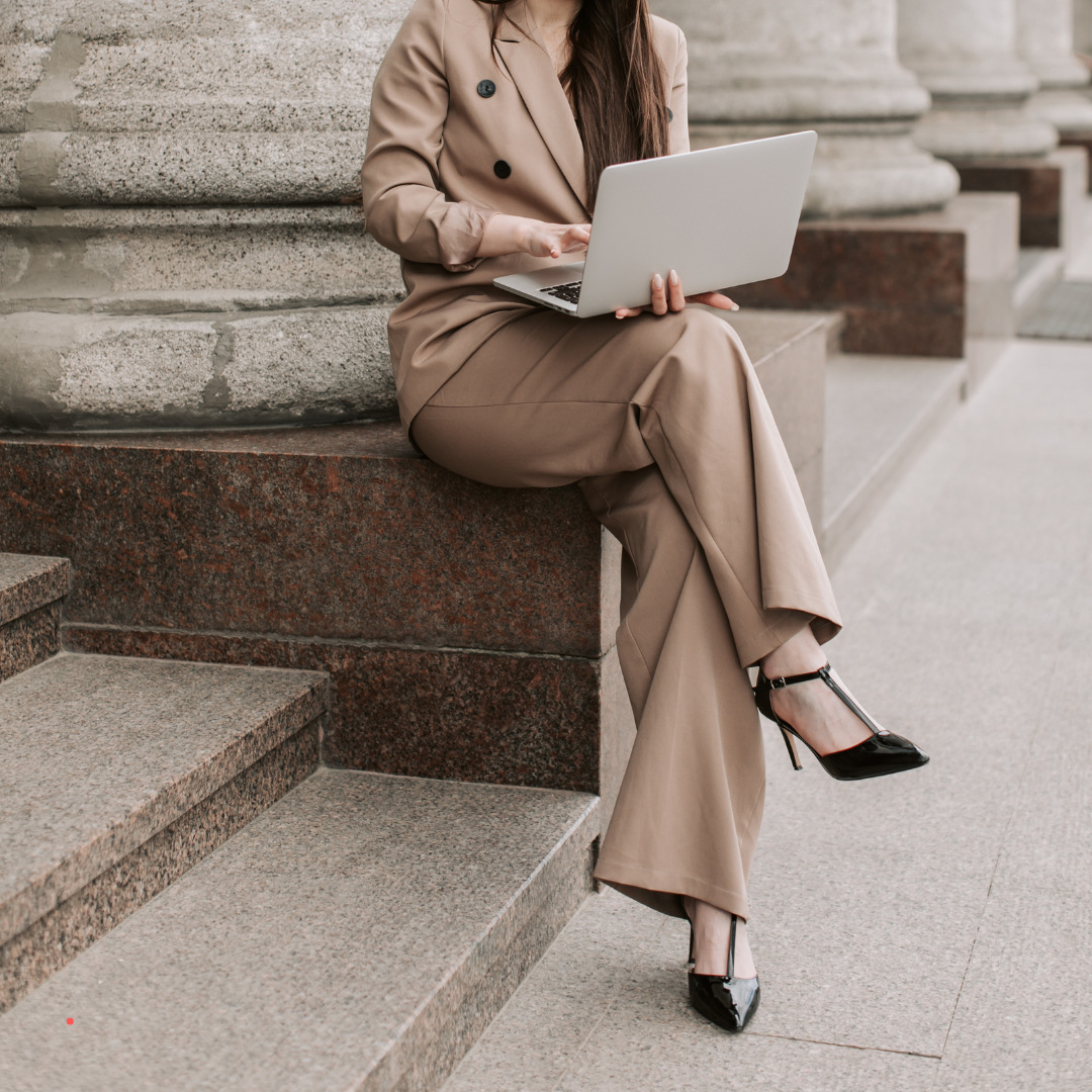 Woman writing on a laptop outdoors, reflecting on thoughts through personal writing.
