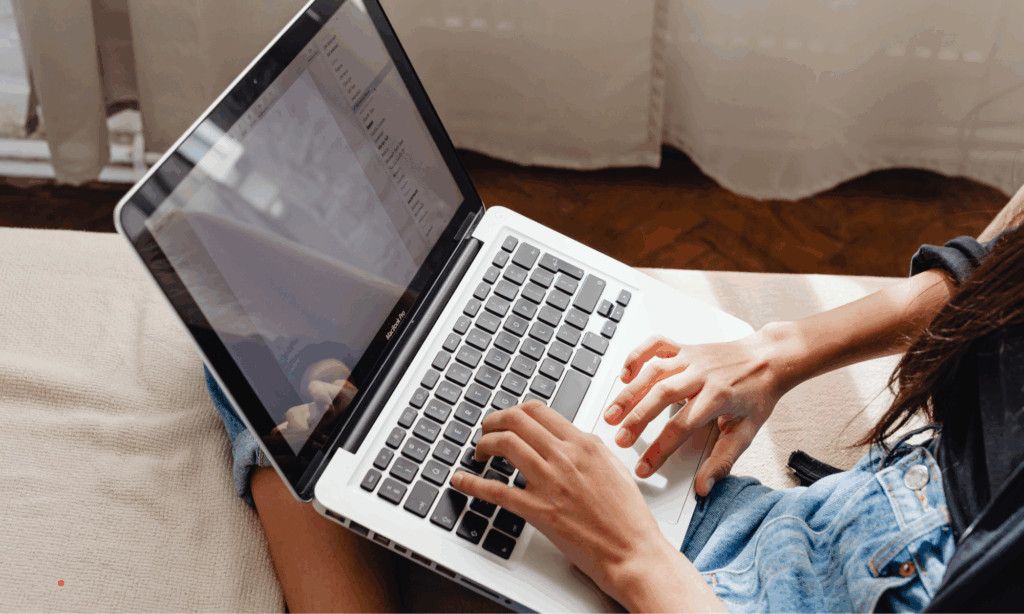 Comfortable at-home writing session on a sofa using a laptop