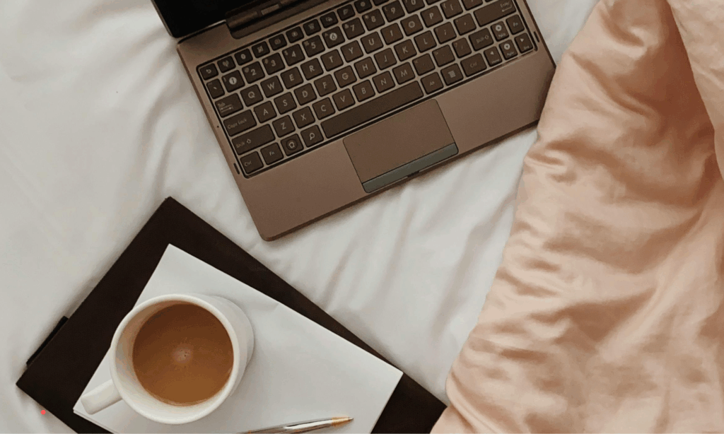 Quiet journaling moment on a bed using a laptop in a calm, safe space