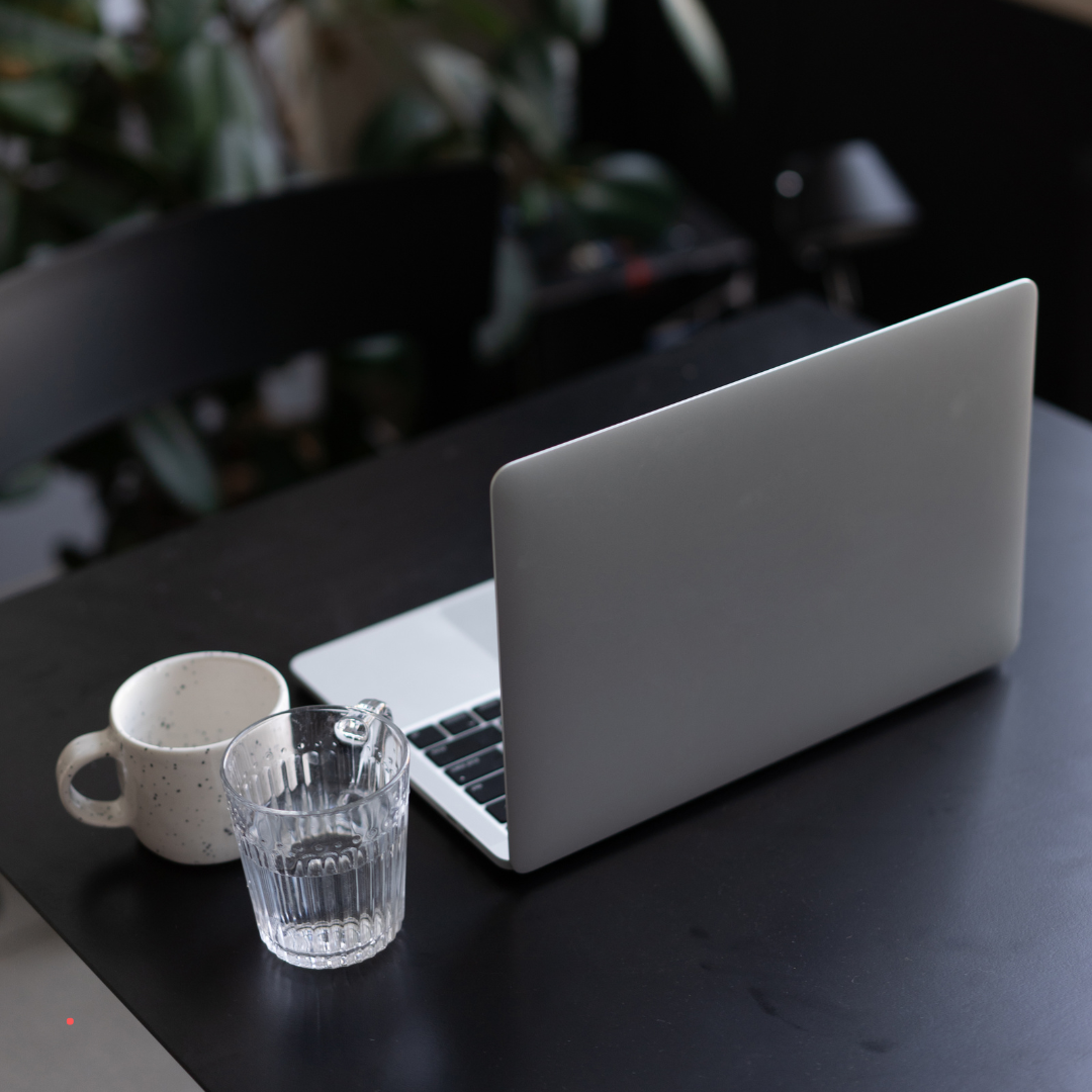 Minimal writing space with laptop and glass of water for focused reflection