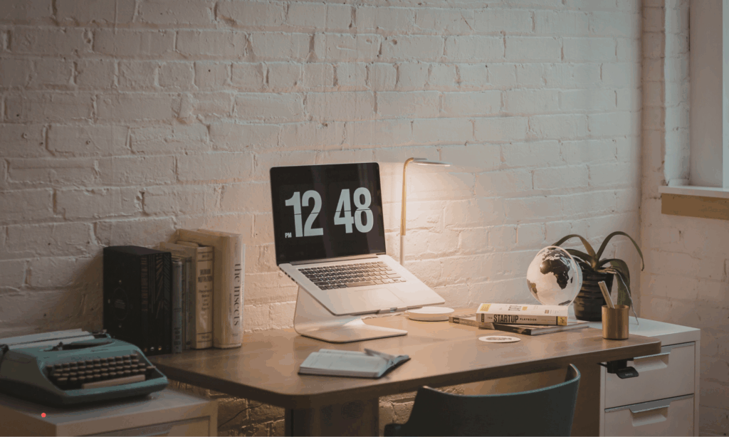 Minimalist writing setup with laptop and books – calm environment for deep journal prompts and self-reflection.