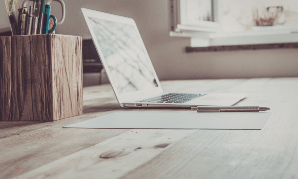 Rustic writing setup with notebook and pen on the wooden table – calm environment for self-reflection during emotional burnout.