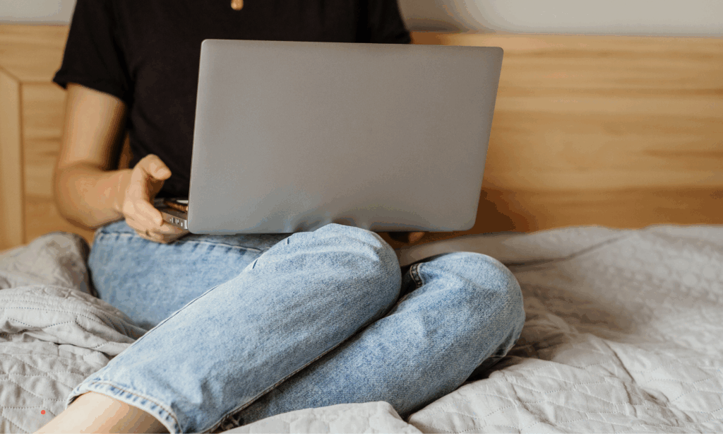 Writing alone on a laptop in bed, creating space for self-reflection and emotional clarity.