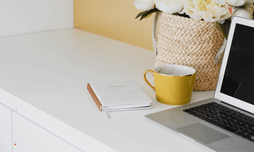 minimal journaling space with notebook, laptop and warm coffee for a calm writing session