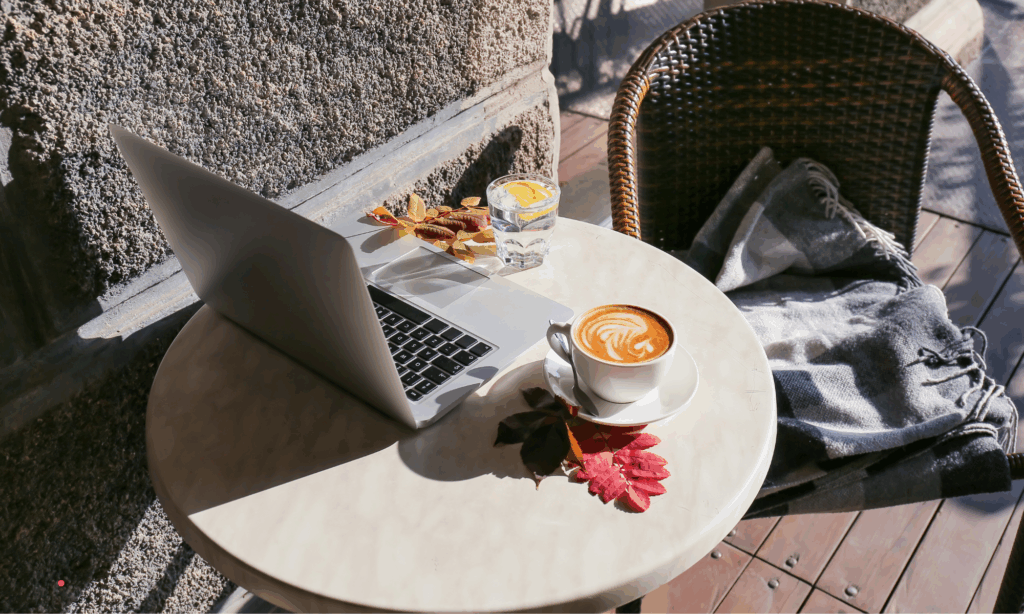 cozy writing setup with laptop and coffee on a small table during a quiet reflective moment