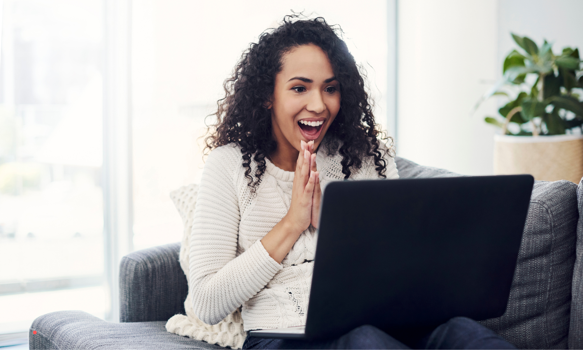 woman reacting emotionally while writing or reading a personal story on laptop